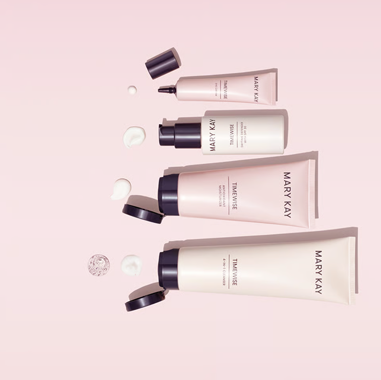 Mary Kay Hautpflegeprodukte, darunter Reinigungsprodukte, Feuchtigkeitspflege und Pflegetuben, arrangiert auf einem zartrosa Hintergrund.